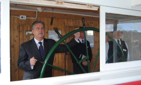 Rear Admiral Kevin Scarce helming Murray River paddle steamer Marion