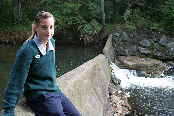 Tessa Berger and the V-notch gauging weir behind the Mahurangi College