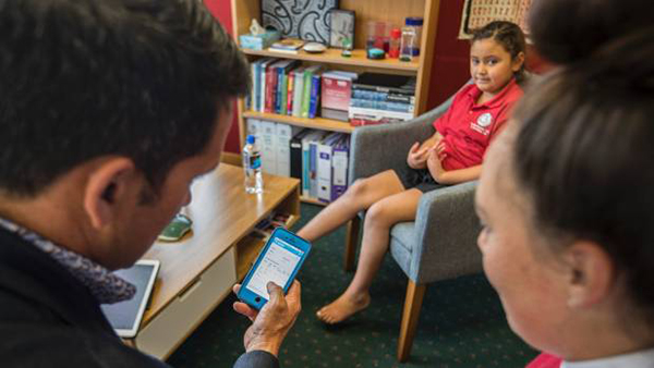 Dr Lance O’Sullivan training school student to use iMoko app