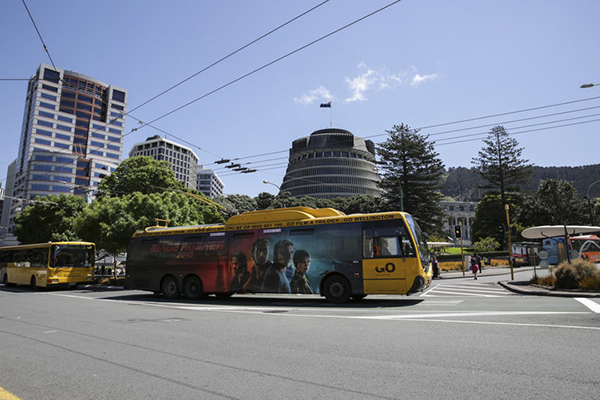 Trolleybus with Executive Wing of the New Zealand Parliament Buildings, the Beehive, in background